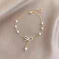The Papillon Perle: Gilded Pavé Bow & Cascading Pearl Bracelet