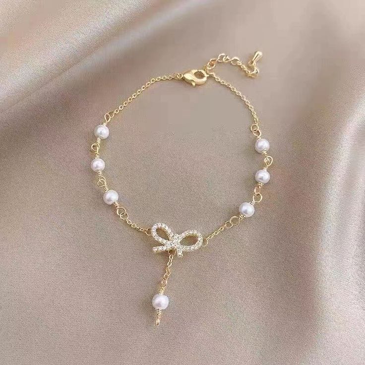 The Papillon Perle: Gilded Pavé Bow & Cascading Pearl Bracelet